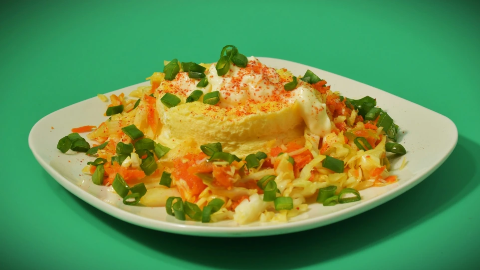 A plate of food with shredded carrots and green onions